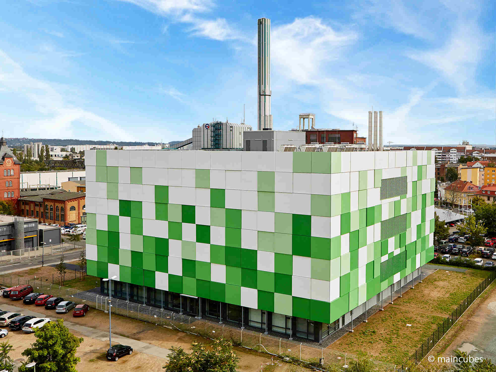 A green and white building in the middle of a city