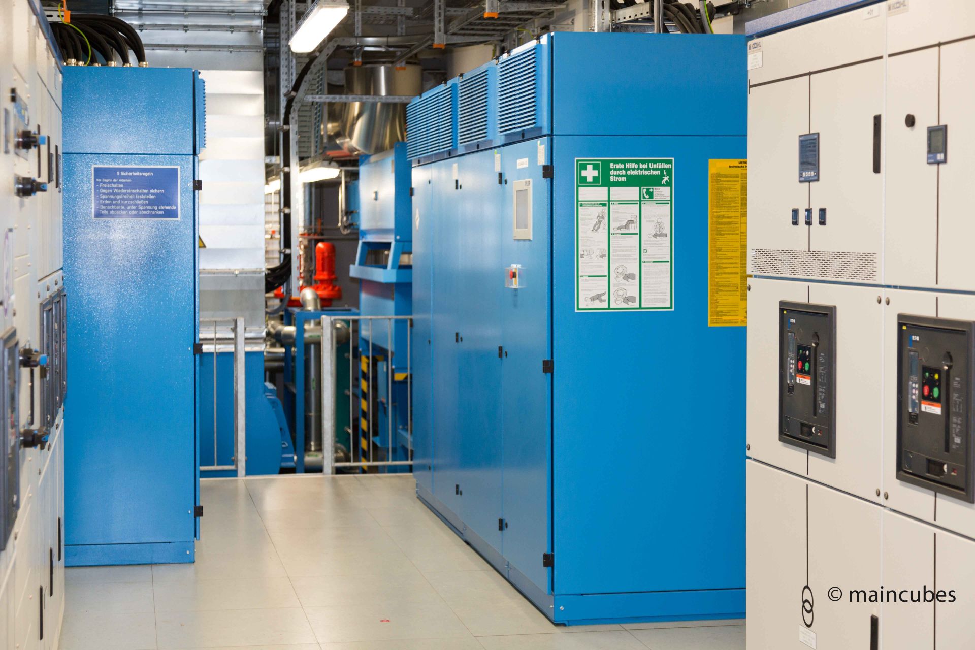 Generator-Raum des maincubes FRA-01, im Hintergrund der Dieselgenerator in blau für Stromausfälle. Links und rechts Schaltschränke